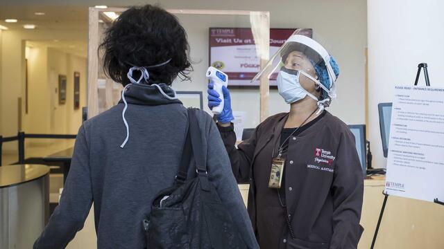 A medical assistant screening a patient