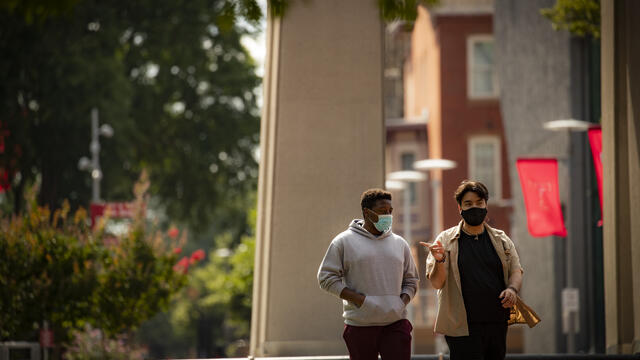Image of two students wearing face coverings walking down Polett Walk on Main Campus.