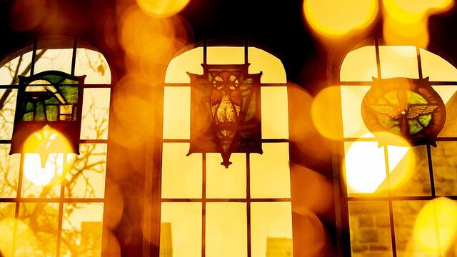 The sun shining through the stained glass windows of Mitten Hall's Great Court.