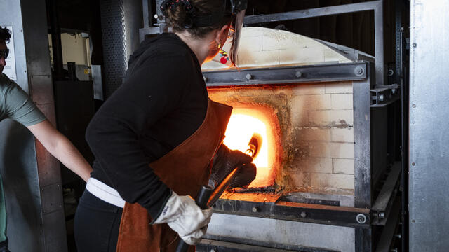 Temple faculty demonstrating glassblowing furnace