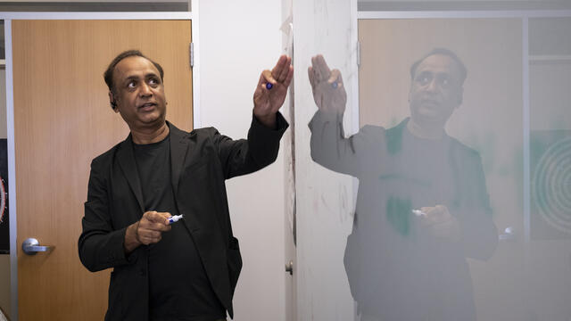 Professor Sudhir Kumar at the white board teaching a small seminar class