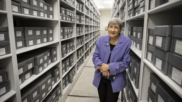 Image of Margery Sly in front of rows of gray boxes.
