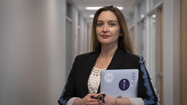Image of Jamie Payton standing with her laptop in hand.
