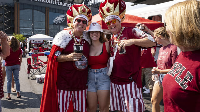 People wearing cherry and white shirts at a Temple University homecoming event.