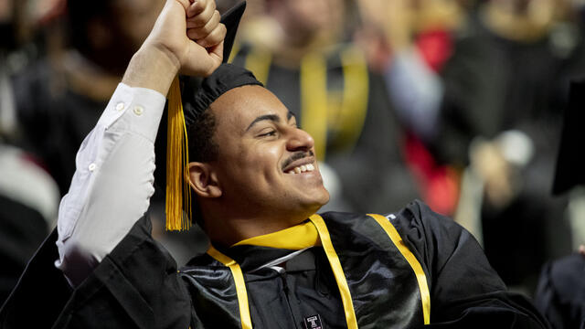 Student at Commencement pumping his hand in the air