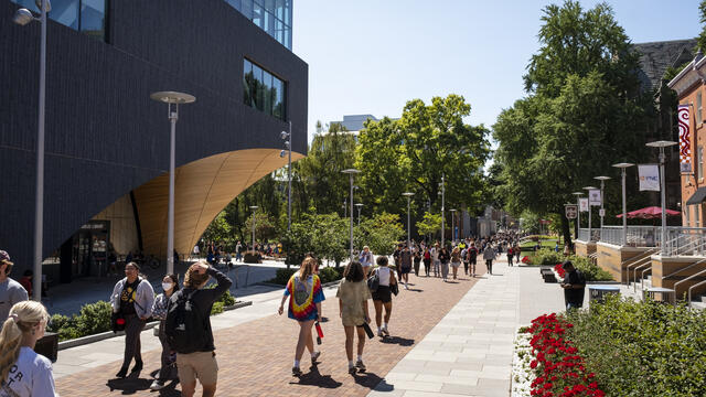 Students walking toward the Bell Tower on a sunny day.