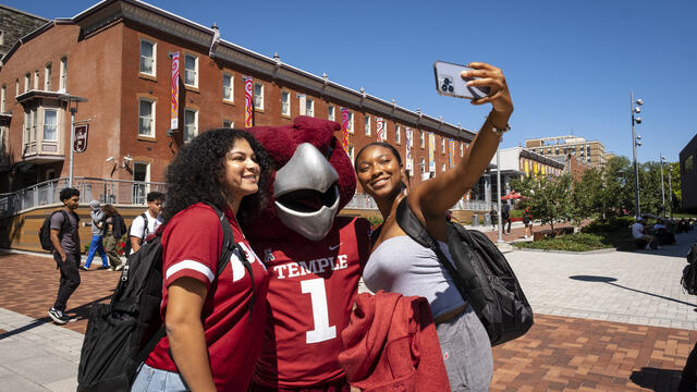 A photo of students taking a photo with Hooter.