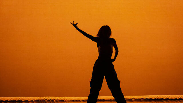 A student's silhouette shown performing at a Temple dance concert