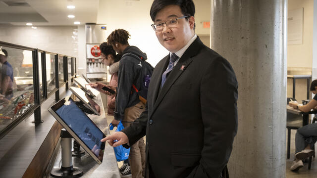 Image of Wangoo Lee at a food ordering kiosk.