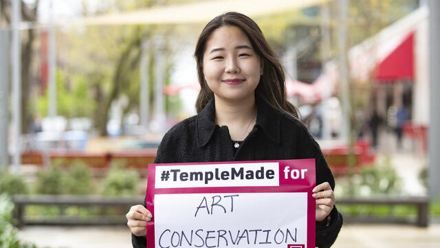 Image of Sera Park holding a sign reading #TempleMade for art conservation.