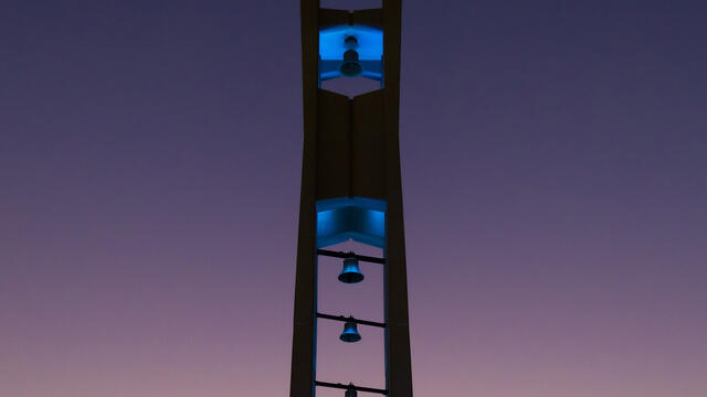 The Bell Tower at night lit up in teal