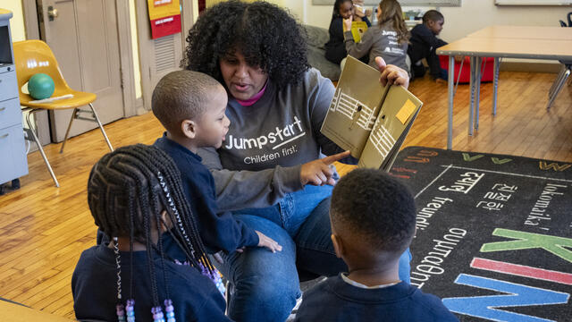 A Temple Jumpstart member reading to preschool children in a classroom at St. Malachy