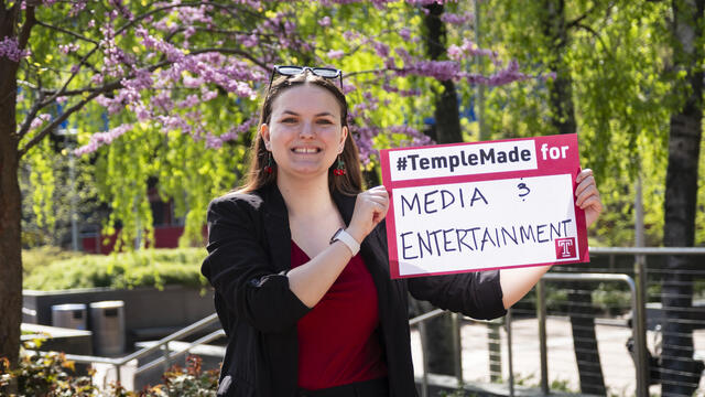 Image of Sydney Binkley holding a sign that reads