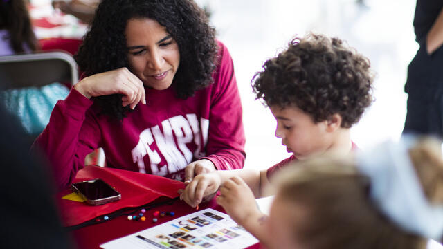 Image of a child with a parent wearing cherry white shirts at Temple.