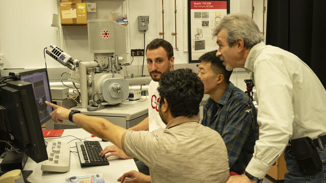 Image of Dmitriy Dikin working alongside researchers.