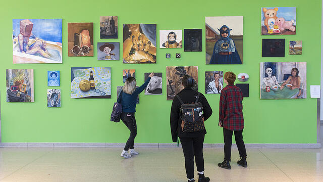 Students looking at a green hallway gallery
