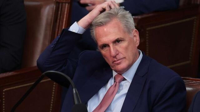 image of representative in a suit sitting and scratching his head