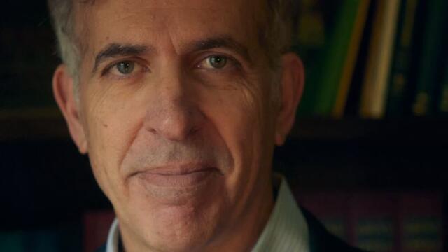 Photo of Dr. Lawrence Indik in front of a bookcase.