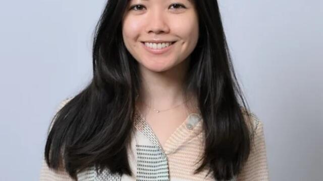 image of Melody with long black hair wearing light pattern blouse smiling at the camera