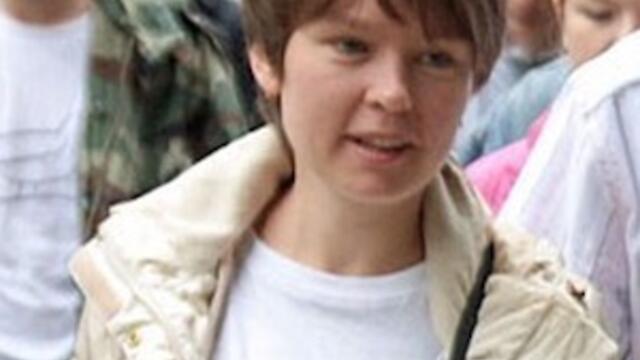 image of Yevgeniya Chirikova standing in a crowd wearing a white tee shirt and cream jacket