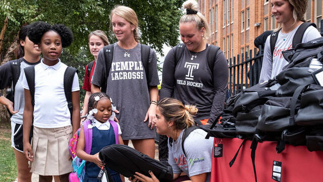 Temple student athletes distribute backpacks to local school students