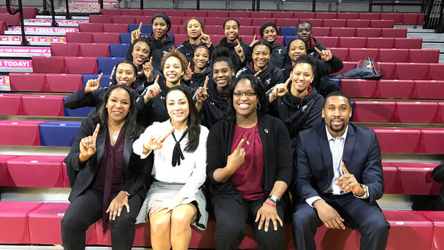 the Temple women s basketball team holding up their fingers to signify No. 1.