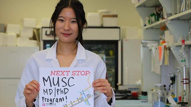 A woman in a white lab coat standing in a research laboratory.