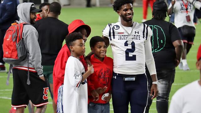 Shedeur Sanders pictured with two young men.