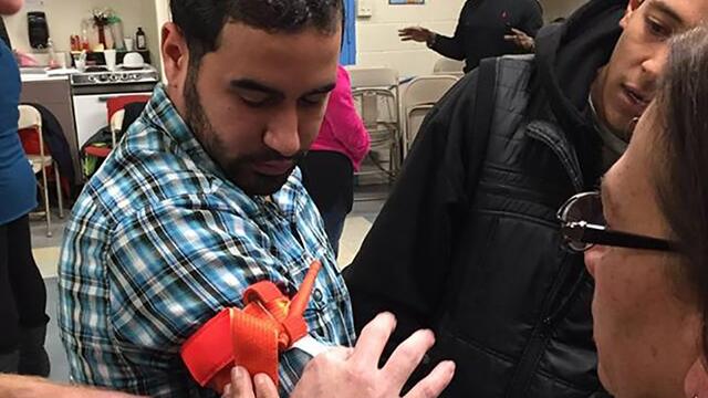 Community members learning to tie a tourniquet.