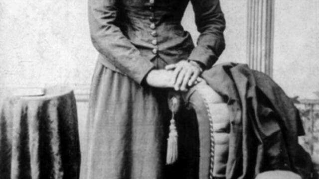Image of Harriet Tubman standing against a chair.
