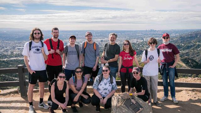 Image of students and faculty posing in front of a fence.
