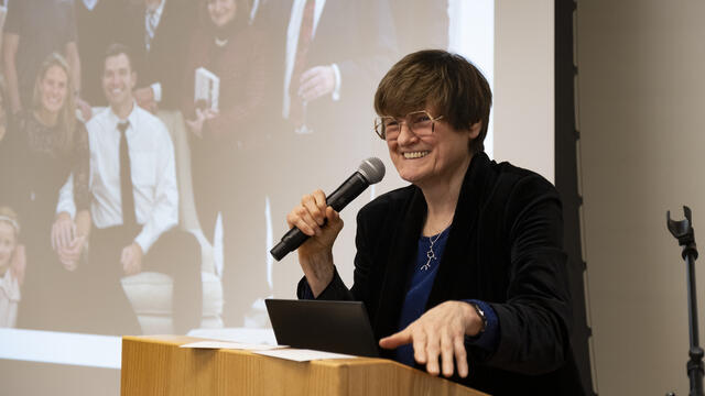 Dr. Kariko standing and speaking at a podium