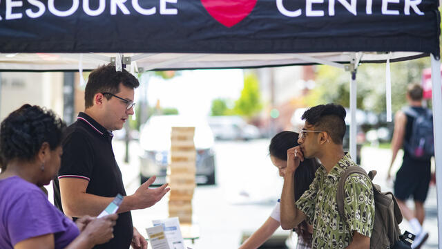 WRC staff member speaks with a student at an outdoor event.