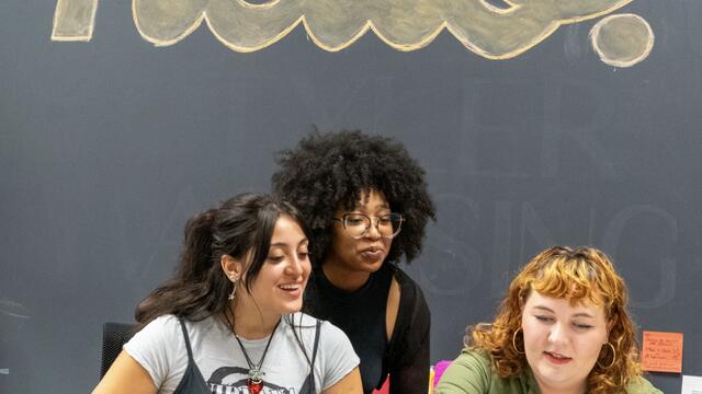 Students in Tyler Advising gather under a "hello" sign. 