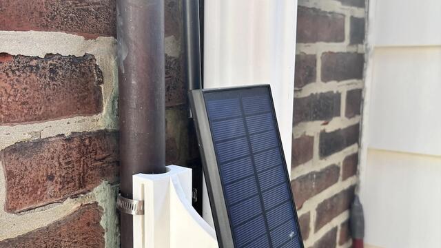Solar panel mounted on a brick wall.
