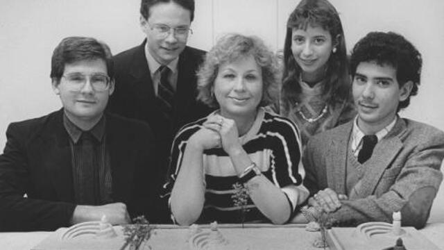 Archival photo of Brigitte Knowles sitting at a table with four other architects