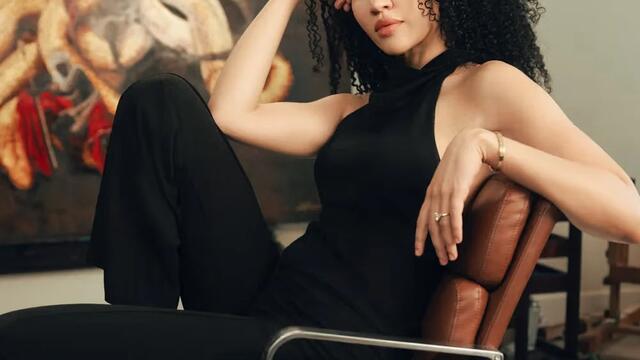 Harmonia Rosales, an Afro-Cuban artist, photographed in front of a painting.