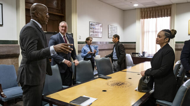 President Wingard speaks with Commissioner Outlaw at a long table
