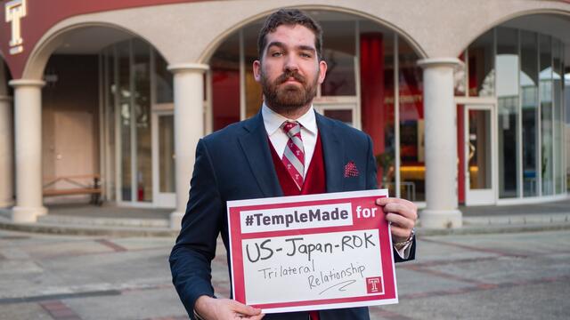 Soren holds sign saying #TempleMade for US-Japan-ROK Trilateral Relationship