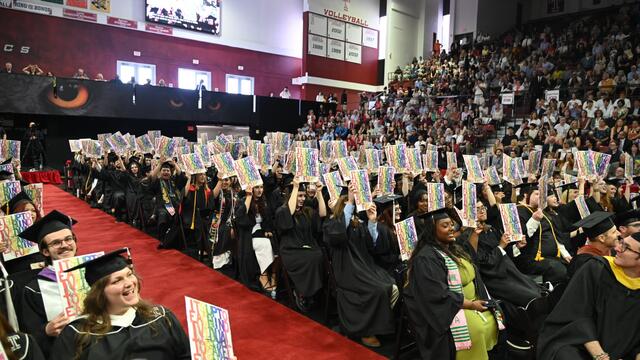 Tyler graduates holding up their Diploma Project print