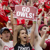 A group of students cheering at a Temple athletic event.