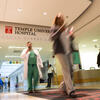 People walking through the entrance to Temple University Hospital.