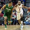 A Temple men s basketball player dribbling a ball as a Tulane player defends.