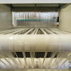 White fabric spinning on a loom.