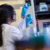 A female researcher cleaning a syringe in a lab.