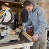 A student using a saw to build the Philadelphia Flower Show exhibit.