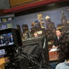 Students in a TV studio preparing to shoot a news segment.