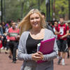 A blond woman holding books on Liacouras Walk.