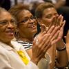 Three women are clapping and smiling.