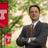 Gregory N. Mandel standing by a Temple flag.